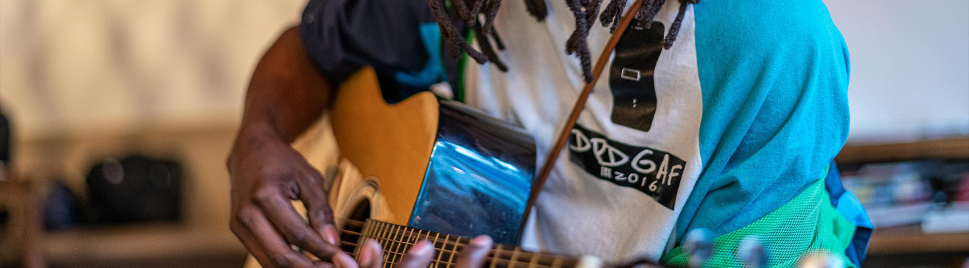 A person playing guitar with an open cell phone.