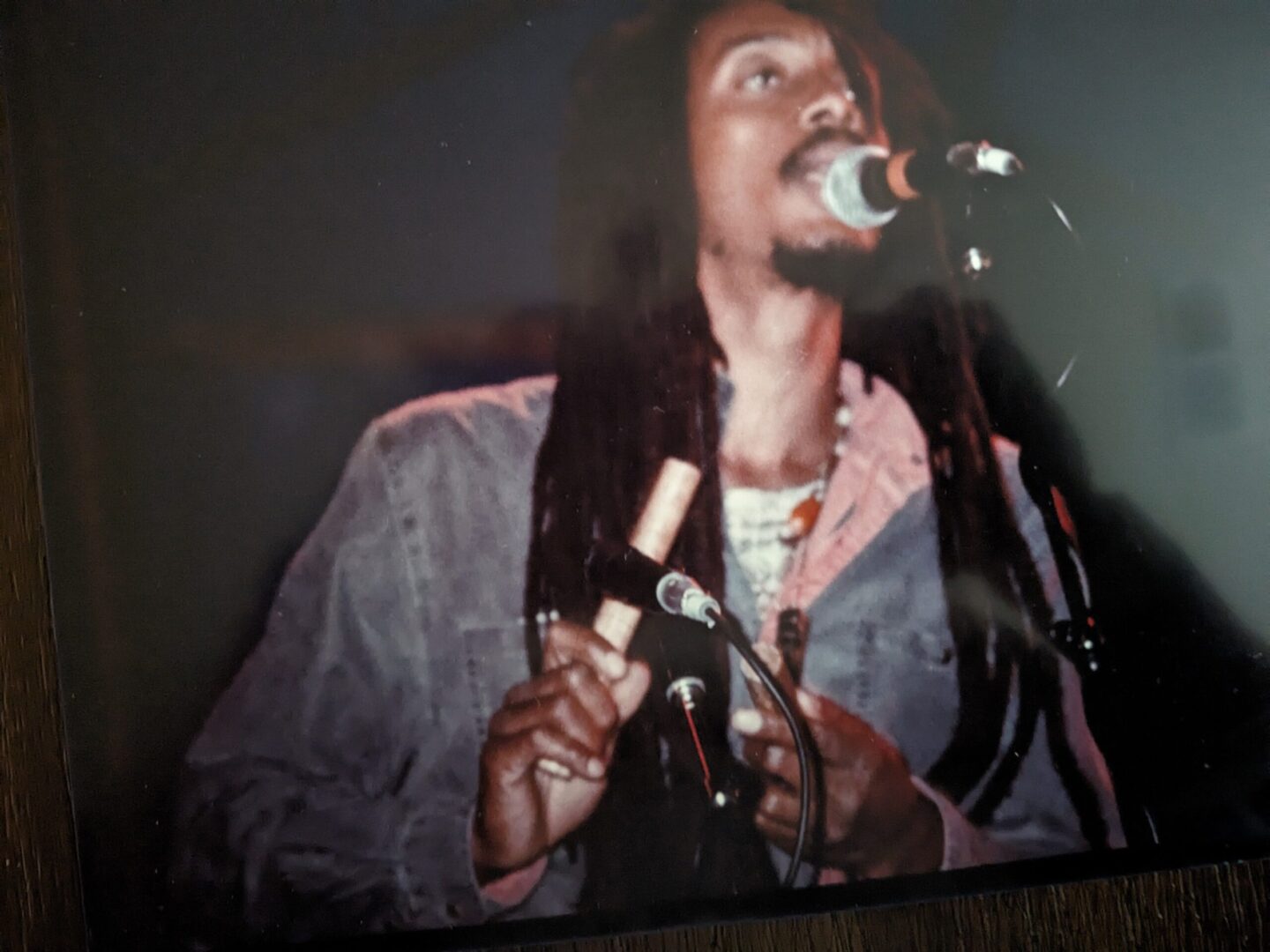 A man singing into a microphone in front of a camera.